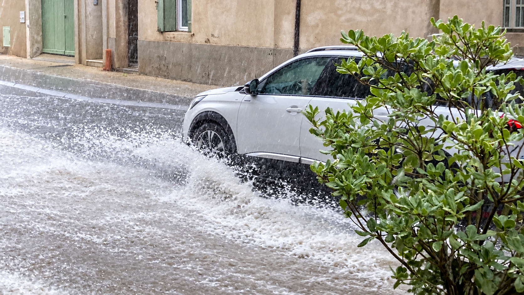 Voiture circulant dans une rue inondée sous de fortes pluies